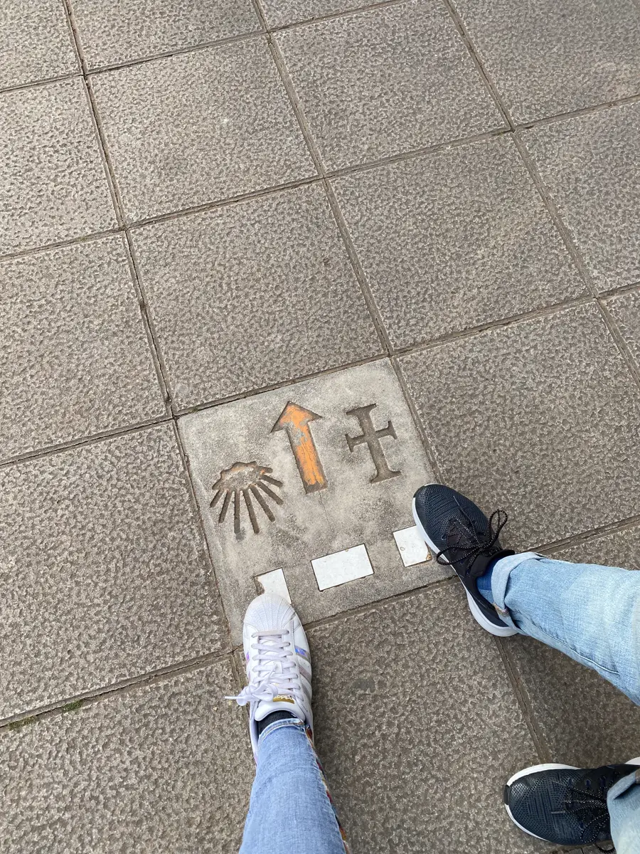 Pilgrims' shoes beside a scallop-shell pavement marker